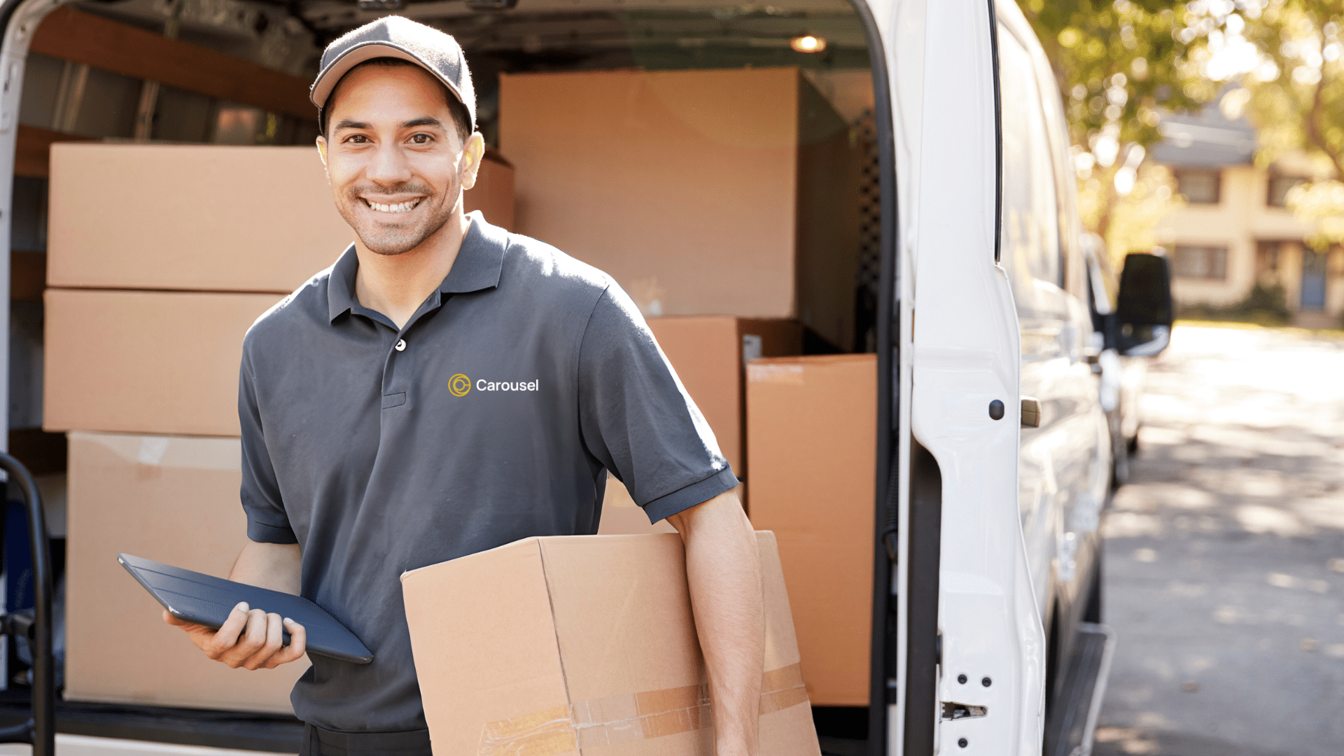 Man wearing grey uniform, smiling while delivering parcel