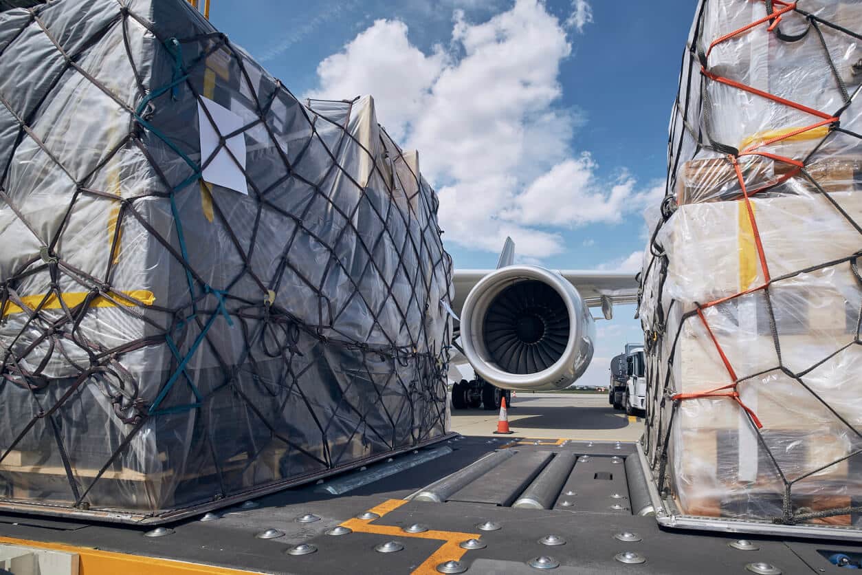 Preparation Before Flight. Loading Of Cargo Containers Against Jet Engine Of Freight Airplane