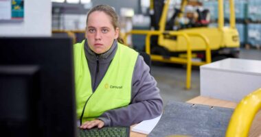 Woman working at computer in a warehouse environment
